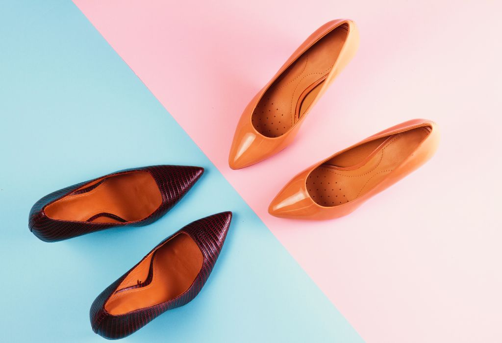 Two pairs of high heels on a split pink and blue background.