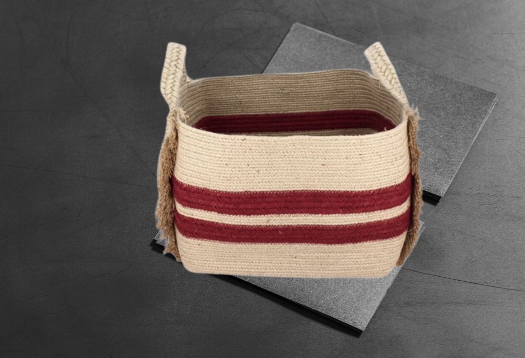 A woven basket with red stripes on a gray textured surface.