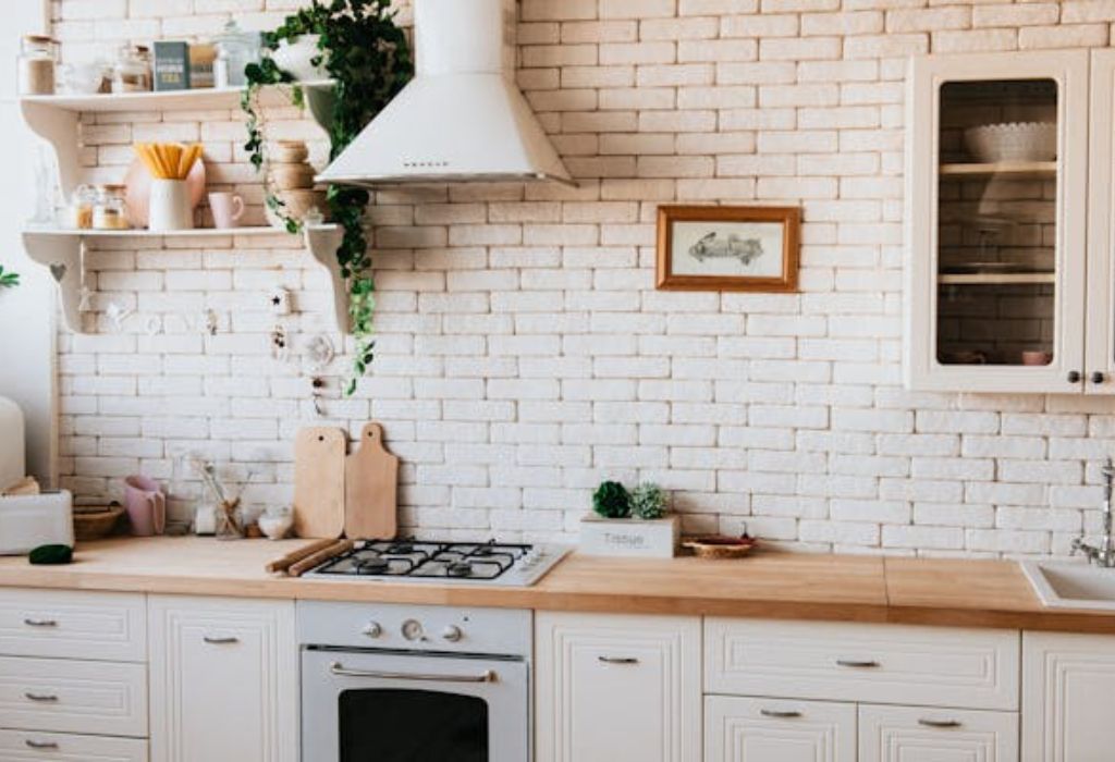 A cozy kitchen interior with white brick walls and wooden countertops.